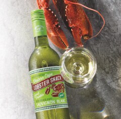 A bottle of Lobster Shack white wine next to a glass of wine and a Lobster